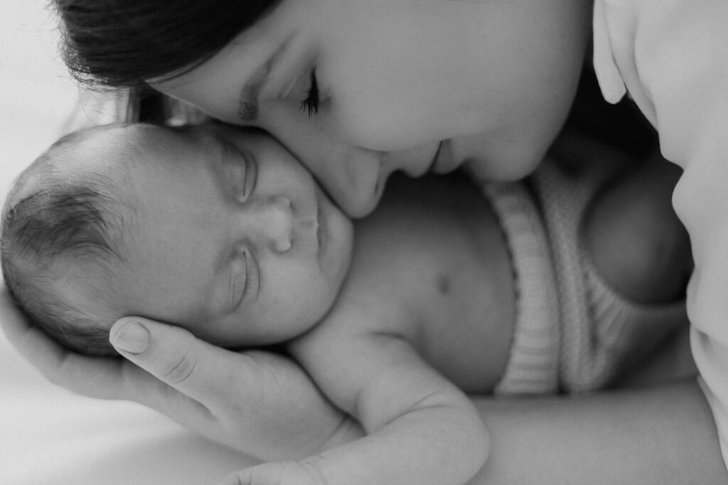 Inniger Moment zwischen Mama und Neugeborenem beim Newborn Shooting